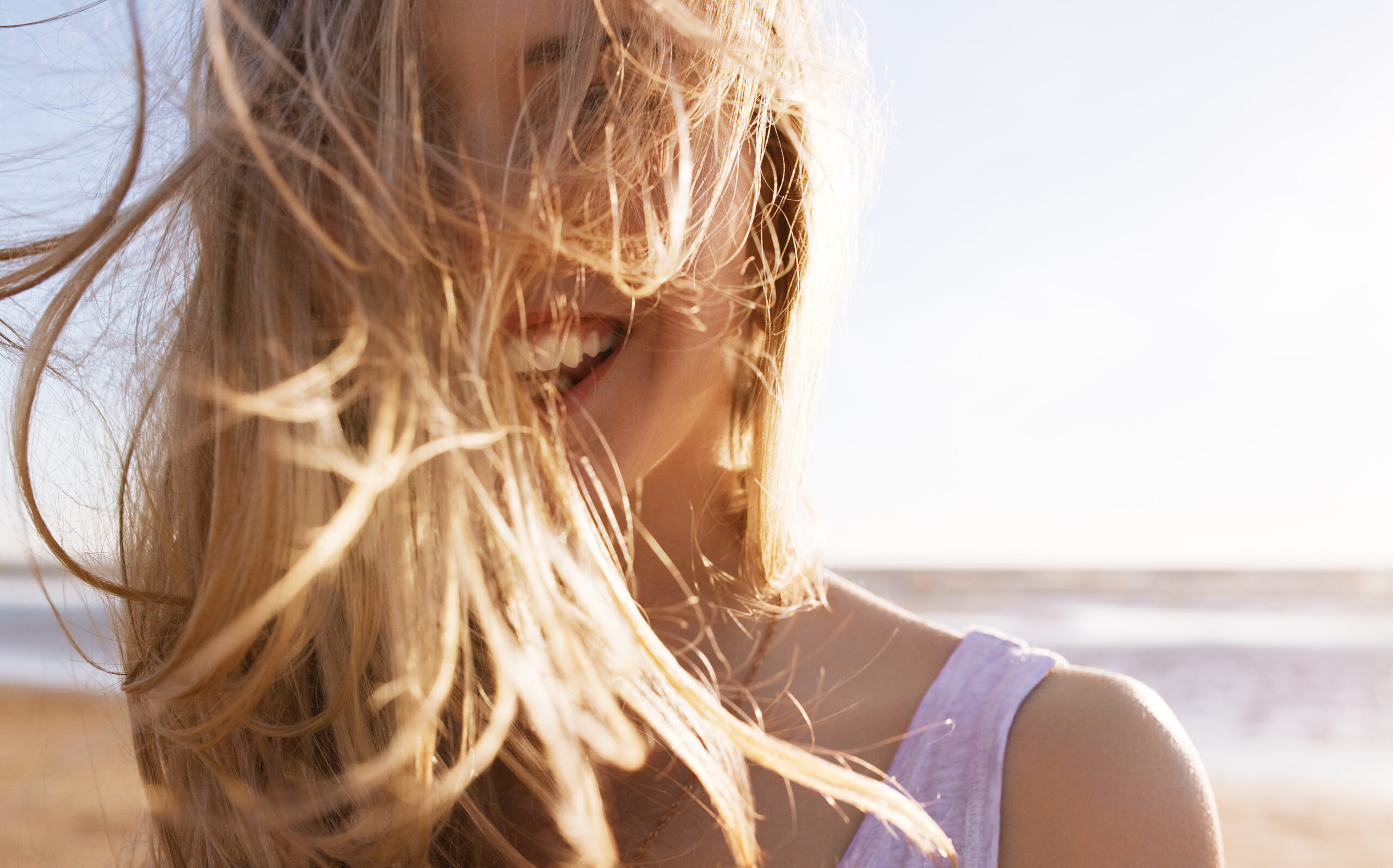 Una donna che ride davanti a una spiaggia